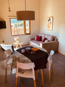 ein Wohnzimmer mit Tisch und Couch in der Unterkunft Casa con magnifica vista al Cerro Catedral in San Carlos de Bariloche