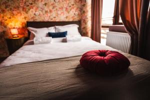a red pillow sitting on top of a bed at The Vardo: Elegant Villa in Predelut in Bran