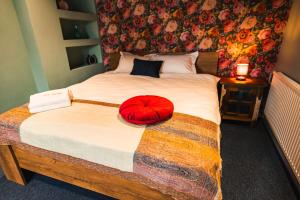 a bedroom with a bed with a red pillow on it at The Vardo - Elegant Villa in Predelut in Bran