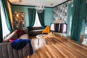 a living room with a couch and a television at The Vardo - Elegant Villa in Predelut in Bran