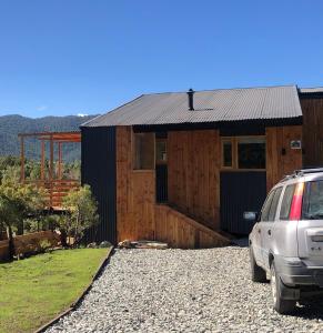 ein vor einem Holzhaus geparktes Auto in der Unterkunft Casa con magnifica vista al Cerro Catedral in San Carlos de Bariloche