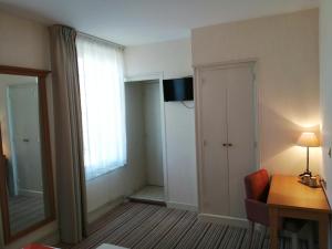TV a/nebo společenská místnost v ubytování Hôtel Les Fleurs