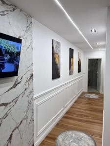 a hallway with art on the walls at Celestia Apartments in Shkodër