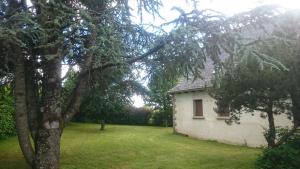 a small white building in a yard with trees at Maison récente type traditionnelle 9 couchages in Trizac +2 photos