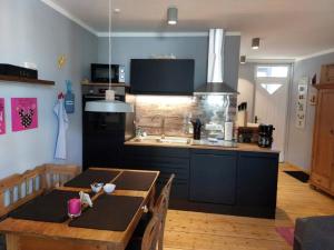 a kitchen and dining room with a table and a kitchen gmaxwell gmaxwell gmaxwell at Spatzennest 2 in Welschneudorf