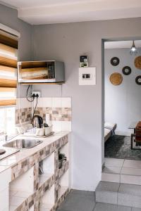 a kitchen with a sink and a microwave at Delightful 1 Bedroom Flat in Germiston with WI-FI in Germiston +12 photos