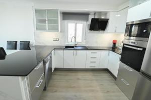 a kitchen with white cabinets and a sink at Etonnante Villa Carrio à Calpe by LG Home in Calpe +45 photos