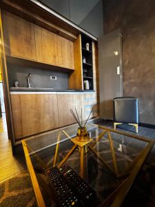 a room with a glass table with two remote controls at Lux A28 in Novi Sad +37 photos