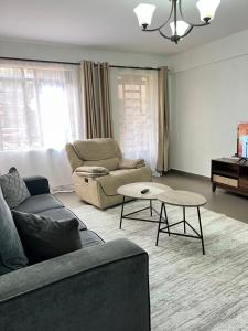 KerichoにあるComfort2 bedrooms in kericho townのソファとテーブルのあるリビングルーム