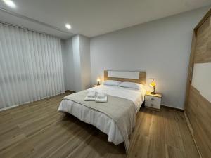 a bedroom with a large bed with two towels on it at Apartamentos La Paz in Ibi