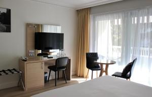 pokój hotelowy z łóżkiem, stołem i krzesłami w obiekcie Hôtel Victoria w Cannes