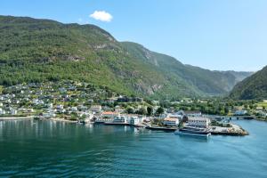 a group of boats docked in a river with mountains at Wangen Apartments in Aurland