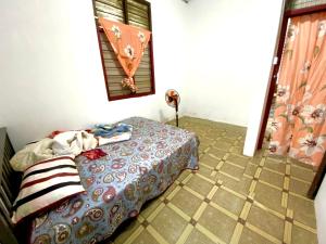 a bedroom with a bed and a tiled floor at MY Gunong Homestay Budget in Bachok