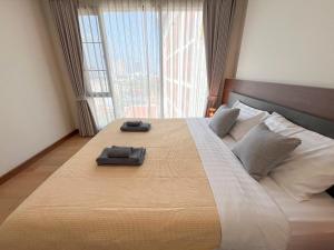 a bedroom with a large bed with a large window at The Astra Residence in Chiang Mai