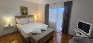 a small bedroom with a bed and a television at Apartmani Meri in Supetar