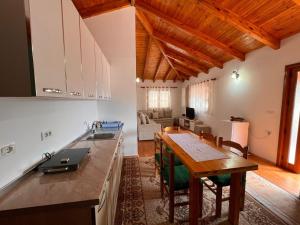 a kitchen and living room with a wooden ceiling at Holiday House in Luftinja e Sipërme