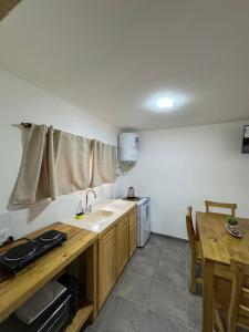 a kitchen with a sink and a counter and a table at Cabañas Boutique La Soñada in Fiambalá +6 photos