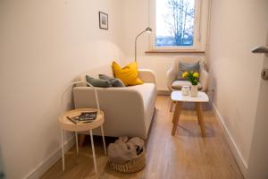 a living room with a couch and a chair at Apartman Esseg - Luxury Living in Historic Esseg - SELF CHECK IN in Osijek +8 photos