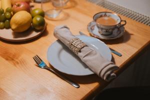 a table with a plate and a cup of coffee and fruit at Apartman Esseg - Luxury Living in Historic Esseg - SELF CHECK IN in Osijek