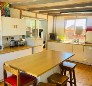 a kitchen with a wooden table and two chairs at OUPAs se Plek in Kontiki