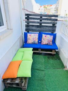 a couch with pillows sitting on a balcony at 70's Hostel in Ericeira