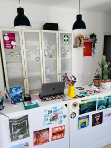 a kitchen with a refrigerator and a laptop on a counter at 70's Hostel in Ericeira