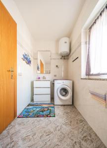 a laundry room with a washing machine and a window at Bosa Mare & Relax in Bosa Marina