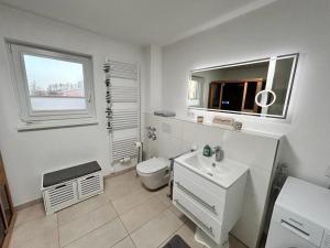 a bathroom with a toilet and a sink and a window at Wera in Butjadingen