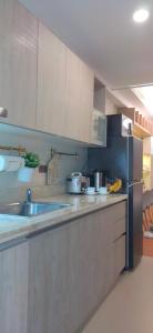 a kitchen with a sink and a refrigerator at Santorini Condotel in Manila +11 photos