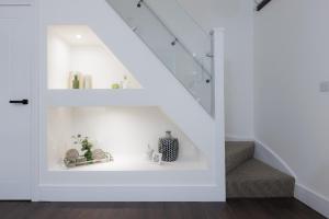 a white staircase with a shelf under the stairs at 5 Stockland Street in Caerphilly
