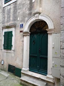 a green door of a building with an arch at Studio Apartman GRACIJA in Herceg-Novi