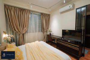 une chambre avec un lit, un bureau et une télévision dans l'établissement Home suites -Natural light -Projector -Spacious - 2BR incenter, à Hanoï