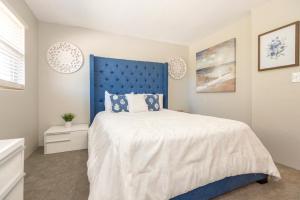a bedroom with a large bed with a blue headboard at New Fall Rates-8 Mins from Beach-Speedway and Golfing in South Daytona