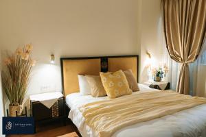 une chambre avec un grand lit avec des oreillers jaunes dans l'établissement Home suites -Natural light -Projector -Spacious - 2BR incenter, à Hanoï 48 autres photos