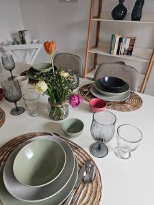 ein Tisch mit Tellern und Gläsern und einer Vase mit Blumen in der Unterkunft Landhaus SoonZauber in Münchwald