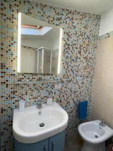 ein Badezimmer mit Waschbecken und Spiegel in der Unterkunft The Seaside Serenity Terrace in Giardini-Naxos