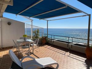 ein Balkon mit Tisch und Stühlen und dem Meer in der Unterkunft The Seaside Serenity Terrace in Giardini-Naxos