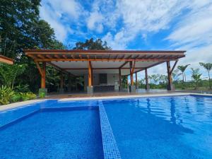 a pool with a pergola next to a swimming pool at Casa Tigrillo - La Fortuna in Agua Azul