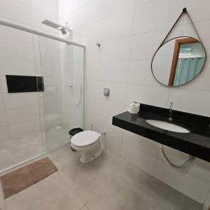 a bathroom with a toilet and a sink and a mirror at Casa Nova 01 in Primavera do Leste +25 photos