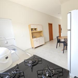 a kitchen with a stove top oven in a room at Casa Nova 01 in Primavera do Leste