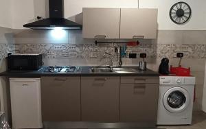 a kitchen with a sink and a washing machine at B&B Giada in Torrazza Piemonte