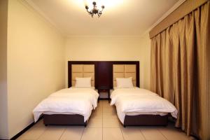 a bedroom with two beds and a chandelier at الجميرة الحديثة in Jeddah
