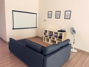 a living room with a blue couch and a white screen at Luxury, Affordable and Spacious Private Villa with Swimming Pool & Jacuzzi for 20 plus ppl Cyberjaya in Cyberjaya