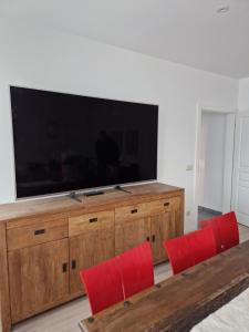 a large entertainment center with red chairs and a large screen television at Sonnenhaus in Joachimsthal