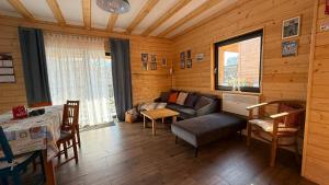 a living room with a couch and a table at Domki Wilcza C in Wilcza