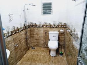 a bathroom with a white toilet and a shower at HANSI Villa in Piliyandala