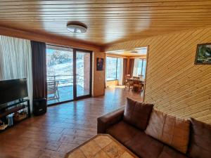 a living room with a couch and a television at Shemoqmedi Chalet in Zemo Makvanetʼi