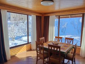 a dining room with a table and chairs and a large window at Shemoqmedi Chalet in Zemo Makvanetʼi +34 photos