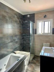 a bathroom with a large tub and a shower at Carmen Apartamento Eleanora in Nerja
