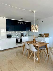 a kitchen with a wooden table and white cabinets at Carmen Apartamento Eleanora in Nerja +11 photos